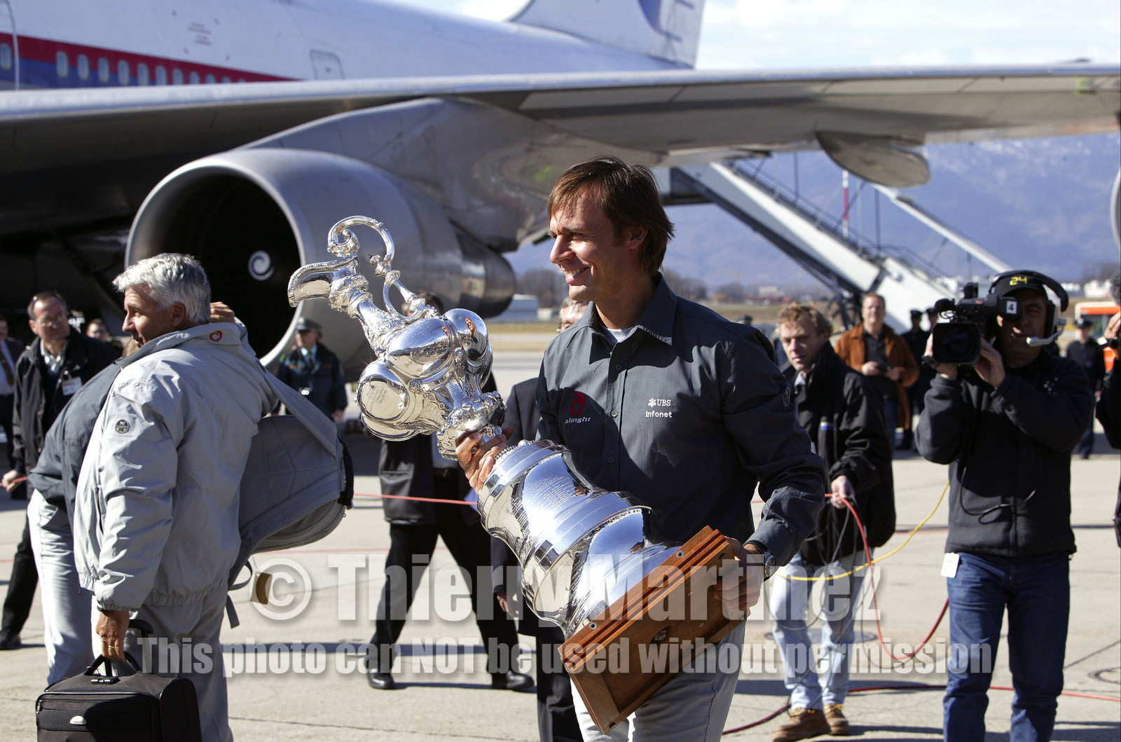 03_2211D ©Th.Martinez Team .Geneva , Switzerland. America's Cup 2003. 8th March 2003.Alinghi Team winner of America's Cup 2003, arriving in Geneva Airport with the America's Cup. Ernesto Bertarelli (Alinghi's president and navigator) with the Cup going out the plane....